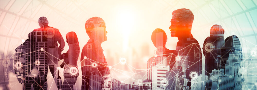 Kreatywny obraz grupy ludzi podczas konferencji na tle miejskiego biurowca, pokazujący sukces partnerstwa w transakcji biznesowej. Koncepcja pracy zespołowej, zaufania i porozumienia.